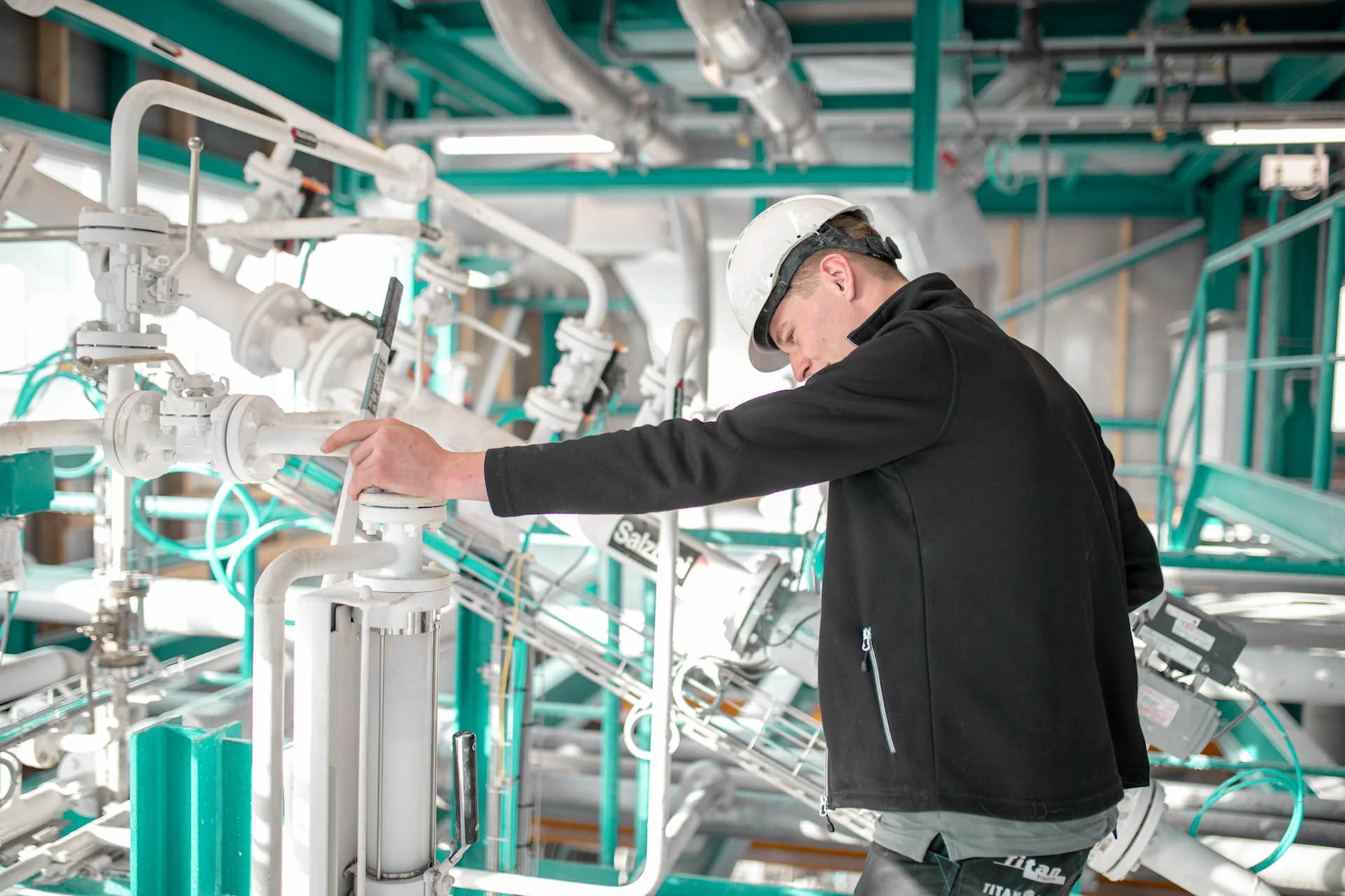 Operator performing safe product sampling in a salt processing installation.